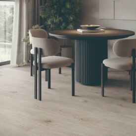 Comedor premium con suelo SPC Alarce Ceniza de TRIP The Natural Company, mesa circular negra listonada, sillas beige y lámpara orgánica