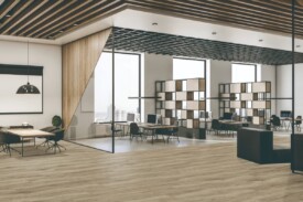 Oficinas modernas de concepto abierto con suelo SPC Cerato Fresno de TRIP The Natural Company, mesas de trabajo, mamparas de vidrio y falsos techos de rejilla de madera.