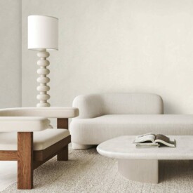 Pared de salón minimalista decorada con revestimiento SPC Skin White de TRIP The Natural Company, sofás de líneas curvas y mobiliario de madera clara.